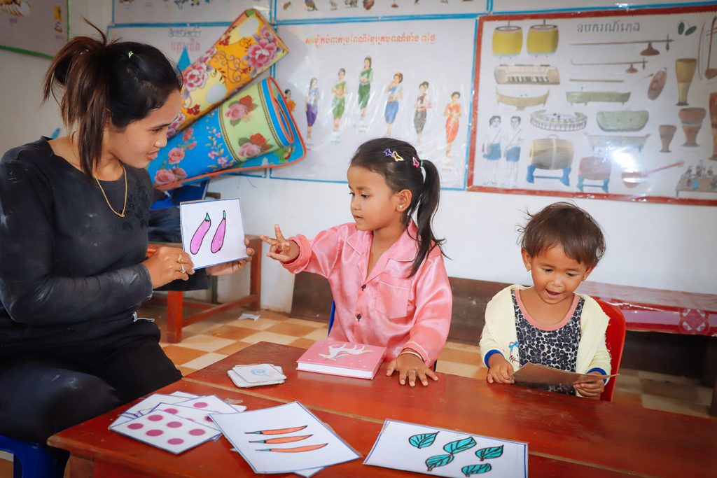 Preschool teacher teaching kids about number